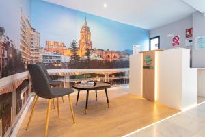 una mesa y una silla en una habitación con vistas en Málaga Rivas 34 Suites Homes en Málaga