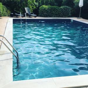 una piscina de agua azul en un patio en Tenuta Santa Maria, en Campagnatico