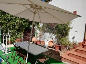 Biały stół z parasolką i roślinami w obiekcie LA CASONA DE VALENZUELA w mieście Valenzuela