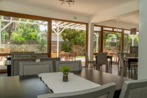 a dining room with tables and chairs and windows at Milies Apartments in Stavros