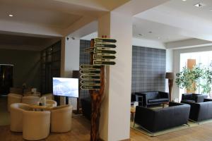 a lobby with a sign with chairs and a television at Hotel Rennsteig in Masserberg