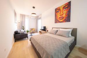 a bedroom with a bed and a painting on the wall at DiVa Lux Apartment in Soho City complex in Bar