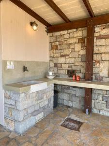 a stone counter in a room with a stone wall at Kalamavros nature home - Kythoikies holiday houses in Kythira