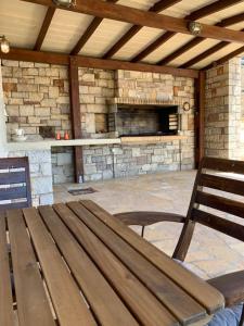 a wooden bench sitting in front of a stone fireplace at Kalamavros nature home - Kythoikies holiday houses in Kythira