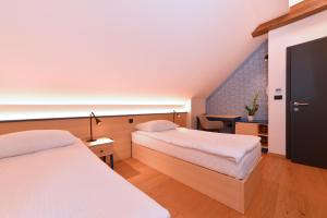 een hotelkamer met 2 bedden en een trap bij Guesthouse Les in Brežice