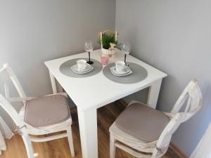 シュチルクにあるOlimpijska pokojeの白いテーブル(椅子2脚、ワイングラス付)