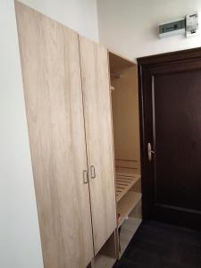 a closet with a wooden cabinet in a room at Robi Studio in Braşov