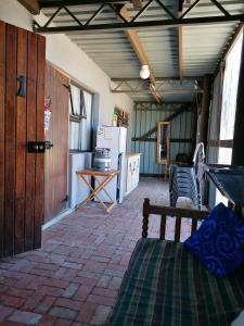 a room with a refrigerator and a table and a bed at Rusthof Accommodation in Gansbaai