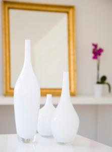 three white vases sitting on a table in front of a mirror at Sandy Beach Hotel & Spa - ex Sentido in Larnaca