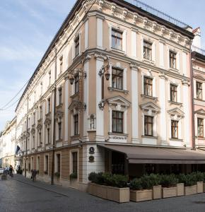 a large white building on a city street at Leopolis Hotel in Lviv