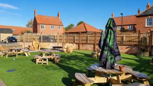 a yard with picnic tables and an umbrella at The Adam and Eve in Wragby
