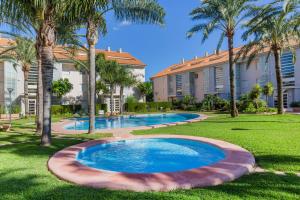 basen w ogrodzie z palmami w obiekcie Golden Gardens Saudade Apartment Javea Arenal by Rock Rentals w mieście Jávea