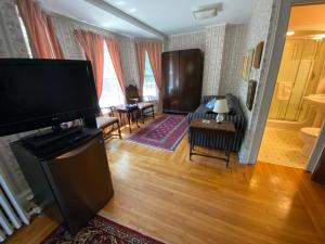 ein Wohnzimmer mit einem Flachbild-TV und einem Sofa in der Unterkunft Bernard Gray Hall Bed and Breakfast in Niagara on the Lake