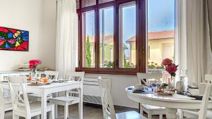 a dining room with white tables and chairs and a window at LA DAMA ROOM&BREAKFAST in Russi