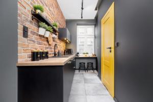 a kitchen with a brick wall and a yellow door at Old Town Studio Good Vibes by Renters in Krakow