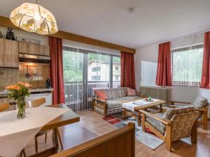 cocina y sala de estar con cortinas rojas en Appartementhaus Montana KG, en Walchsee