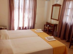 A bed or beds in a room at Alexandra Hotel