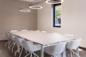 une salle de conférence avec une table et des chaises blanches dans l'établissement B&B HOTEL Lisboa Montijo, à Montijo