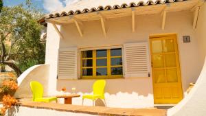 a house with yellow chairs and a table and a window at Villaggio Placido in Taormina