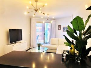 a living room with a couch and a tv at Rentcostadelsol Fuengirola Doña Sofia 3D in Fuengirola