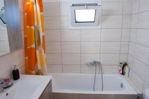 baño con bañera y ventana en OLIVES Estate APARTMENTS, en Preveza