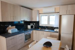 a kitchen with a table and a white refrigerator at OLIVES Estate APARTMENTS in Preveza