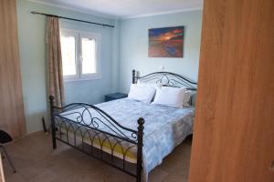 sypialnia z łóżkiem z niebieskimi ścianami i oknem w obiekcie OLIVES Estate APARTMENTS w Prewezie
