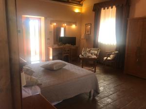 a bedroom with a bed and a desk and a television at Casale Certosa in Pavona