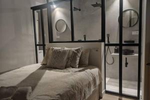 Schlafzimmer mit einem Bett mit zwei Spiegeln an der Wand in der Unterkunft SUITEUMBRIA, diseño y relax en la playa! in Punta Umbría