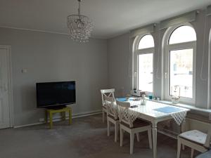 une salle à manger avec une table et une télévision dans l'établissement APARTAMENT DLA TURYSTÓW SOPOT, à Sopot