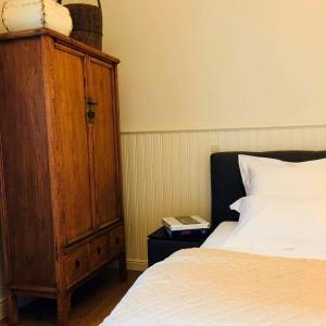 ボルフローンにあるKirisavan Bed&Breakfastのベッドルーム1室(ベッド1台付)、木製キャビネットが備わります。