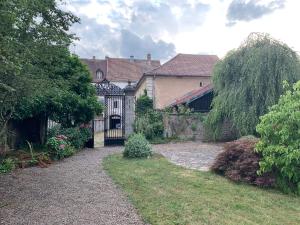 una casa con una puerta en un patio en Les Jardins d'Élise, calme et verdure à Lure, en Lure