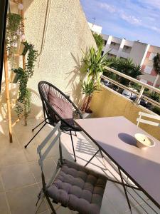 einen Balkon mit einem Tisch und einem Stuhl auf dem Balkon in der Unterkunft L’IODE MARINE in La Ciotat
