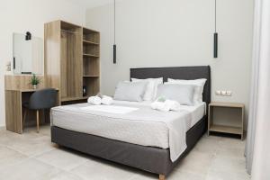 een slaapkamer met een groot bed en een bureau bij Comodo in Nydri