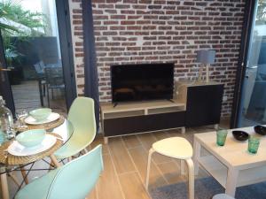 sala de estar con chimenea, mesas y sillas en Les spas de la Chartreuse en Tarbes
