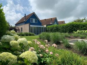 a blue house with a garden in front of it at Suite & Wellness in Breskens