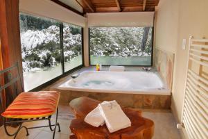 ein Badezimmer mit einer Badewanne und einem großen Fenster in der Unterkunft Posada del Sauce in Villa General Belgrano