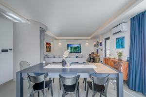 comedor y sala de estar con mesa azul y sillas en VILLA ELEMENTA - A peaceful retreat en Milna