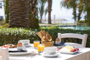 a white table with breakfast food on it at Sandy Beach Hotel & Spa - ex Sentido in Larnaca