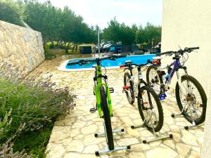 dos bicicletas están estacionadas junto a una piscina en Villa Cvita, en Povljana