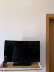 a flat screen tv sitting on a table with a remote control at Marija in Šibenik