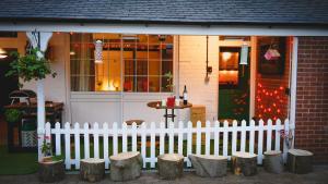 a white picket fence in front of a house at Garden Cottage at Old Post Office in Bardon Mill