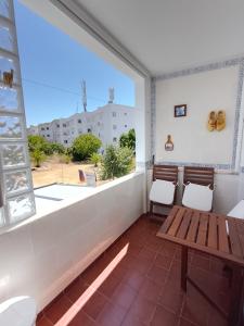 a balcony with two chairs and a table and a window at Casa Florival in Burgau