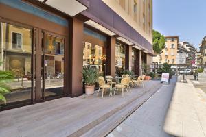 a store front with tables and chairs on a sidewalk at Hotel du Pin Nice Port in Nice