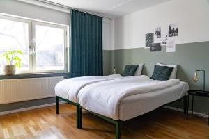 a bedroom with a large bed and a window at Botanika Uppsala in Uppsala