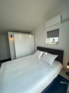 a bedroom with a large white bed and a window at Water Villa Minaro Vinkeveen in Vinkeveen
