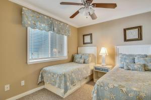 1 dormitorio con 2 camas y ventilador de techo en Seascape 1210 Condo, en Galveston