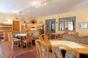 a dining room with tables and chairs in a restaurant at Hotel-Pension Störtebeker in Bensersiel
