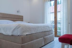 a bedroom with a large bed and a balcony at Villa Lara in Žabljak +61 photos