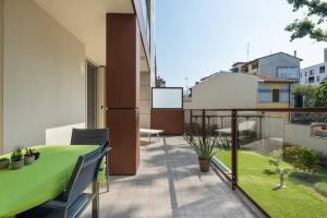 Appartamento dotato di balcone con tavolo e sedie verdi. di Easylife - Modern and Spacious apt in Fiera City Life a Milano